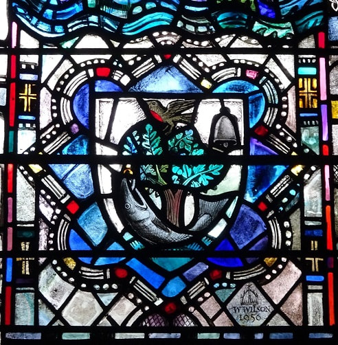 Stained glass in Glasgow Cathedral depicting the bird, tree, bell, fish motif within a shield shape