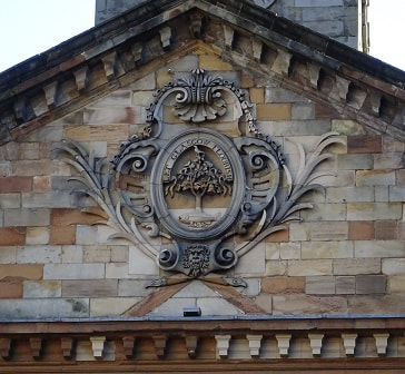 yellow sandstone carved 18th century variation of the coat of arms on the front of St Andrews in the Square